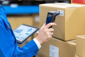 Hand of a person holding a barcode scanner to a box